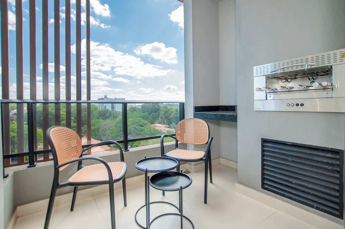 Ein Balkon mit Blick, einem Grill und zwei Stühlen.