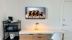 Un ufficio moderno con scrivania, sedia e televisione a muro che mostra cuccioli.