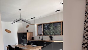 Eine moderne Küche mit Essbereich, Holzboden und einem Blumentopf.