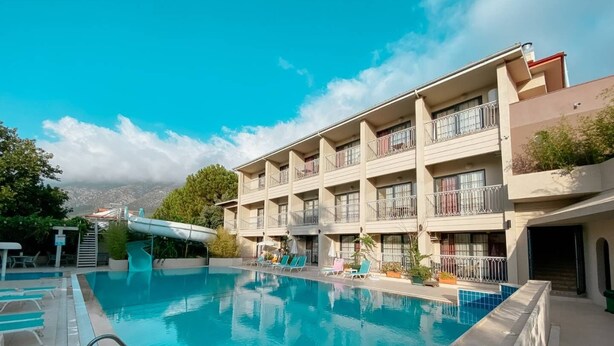 Ett hotell med en swimmingpool, flera balkonger och utsikt över staden.