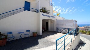 Un bâtiment appelé « Kissonergia Seaview », doté d’un escalier, d’un espace extérieur aménagé pour s’asseoir et offrant une vue sur la mer.