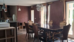A dining area with a marble table, dark chairs, pendant lighting, and a chandelier. - House with a pool; 4 bedrooms, including 2 with double beds (Chassey-le-Camp)