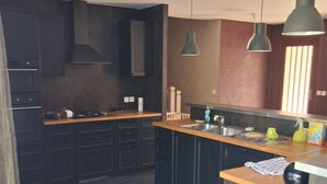 A modern kitchen with dark cabinets, a wooden countertop, a sink, and a trash bin. - House with a pool; 4 bedrooms, including 2 with double beds (Chassey-le-Camp)
