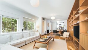 Ein modernes Wohnzimmer mit einem weißen Sofa, einem Holztisch und einem Essbereich mit einer Tafel.