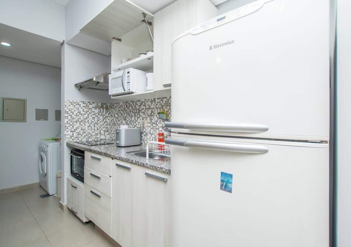 A modern kitchen with a built-in refrigerator, microwave, and oven.