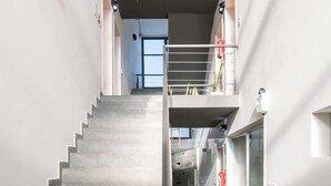A staircase with a metal railing leading to a second-floor balcony with a glass railing. - Corporate Stays Terraza flats (Asunción)