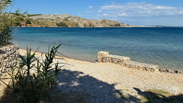 A coastal landscape with clear water, rocky terrain, and vegetation. - 1 bedroom beach front apartment in Smokvica (Smokvica)