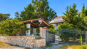 A stone wall, a metal gate, and a building with a tiled roof. - 1 bedroom beach front apartment in Smokvica (Smokvica)