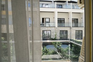 A multi-level building with balconies, a courtyard, and a view through a window.