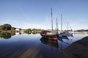 A calm lake with boats docked, clear skies, and a shoreline with vegetation. - Brittany house with garden, Gulf 200m away (Sarzeau)