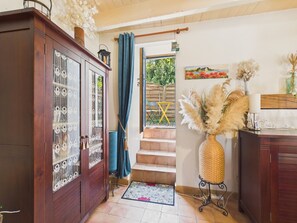 A wooden cabinet with glass doors, a wicker vase with pampas grass, and a painting on the wall. - Brittany house with garden, Gulf 200m away (Sarzeau)