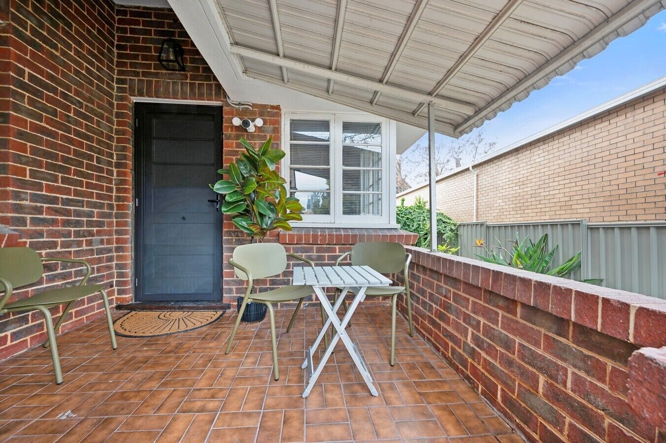 A patio with a table and chairs, a door, and a window.