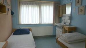 A room with two beds, a window with curtains, a sink, and a mirror. - Family Bungalow With Enclosed Garden (Koudekerke)