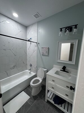 A bathroom with a bathtub, toilet, sink, and mirror. - Hermosa casa Nueva de 3 habitaciones y 2 Banos, parqueadero 2 autos (Salisbury)