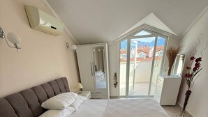 A bedroom with a bed, a wardrobe, a mirror, and a view of the outside. - Beautiful 2-bedroom condo with AC in enchanting in Sunset Beach Club,Fethiye (Muğla)