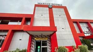 Un edificio moderno con una decoración en rojo y blanco, una zona de recepción y un cartel que dice 'MARTIN HOTELS'.