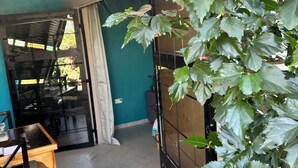 Une pièce avec vue sur un jardin, une table en bois et une chaise.