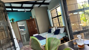 Une chambre à coucher avec un lit, une fenêtre, un lavabo et une plante en pot.