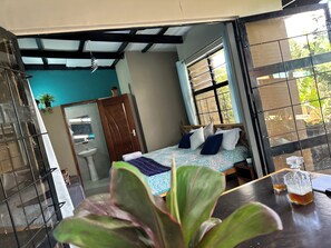 Une chambre à coucher avec un lit, une fenêtre, un lavabo et une plante en pot.