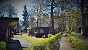 Une rangée de cabanes, avec un chemin pavé et de la verdure.