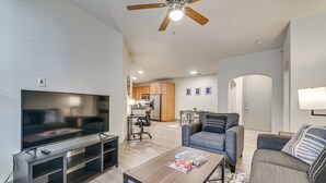 A modern living room with a flat-screen TV, a wooden coffee table, a gray sofa, and a ceiling fan. - Pet-friendly Condo w/ Community Perks in Dallas! (Dallas)