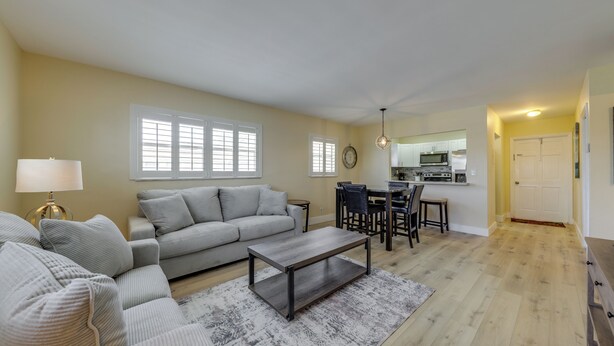 A living room with a sofa, coffee table, and dining area. - Walk to Beach, Steps to Pool, Beach Chairs (Pompano Beach)