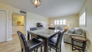 A dining area with a table and chairs, a sofa, a TV, and a lamp. - Walk to Beach, Steps to Pool, Beach Chairs (Pompano Beach)