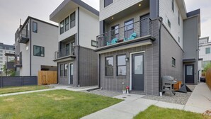 Un immeuble résidentiel moderne à plusieurs étages, doté de balcons, d’un garage apparent et d’une pelouse bien entretenue.