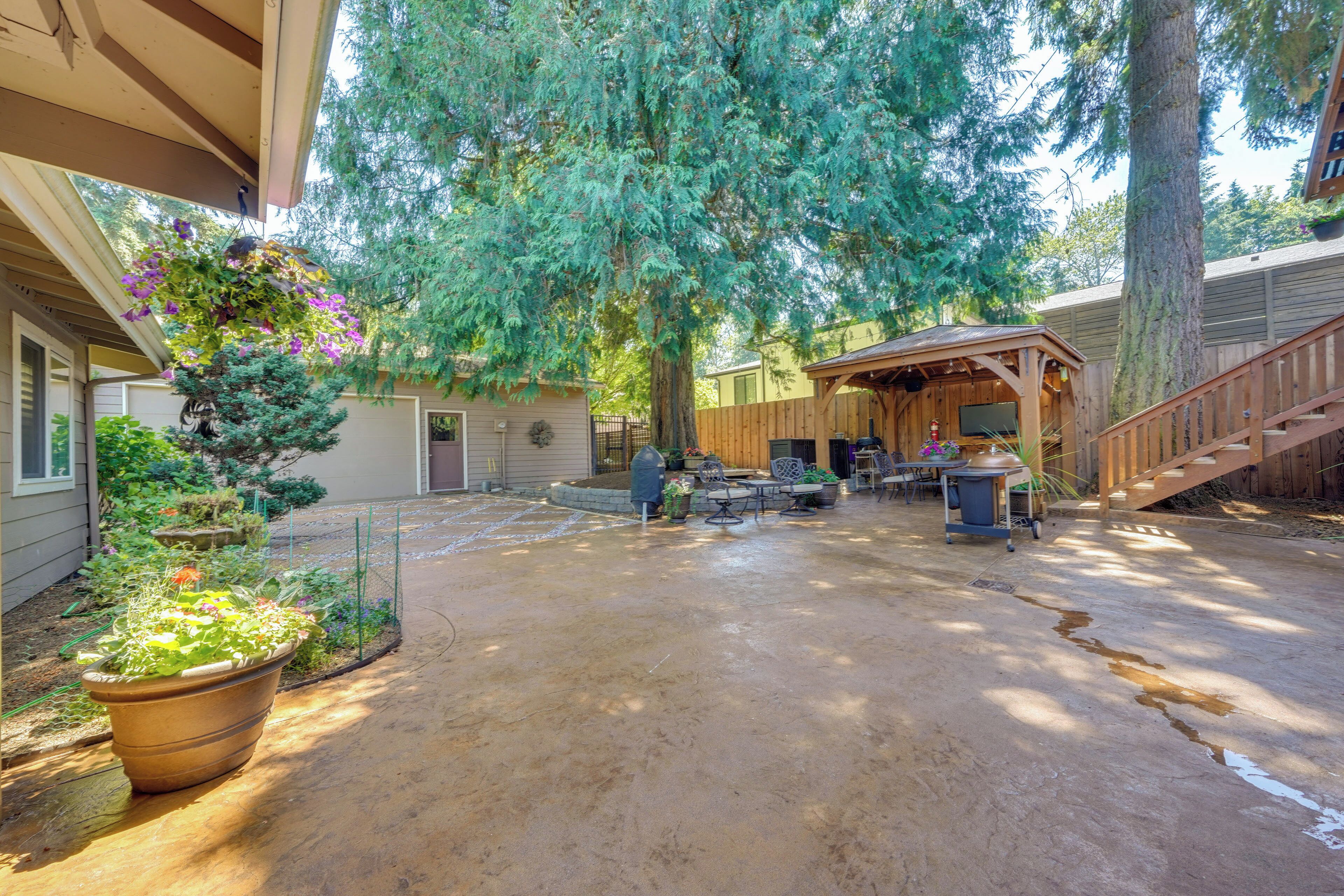 A covered patio with a concrete floor, a wooden deck, and a pergola.