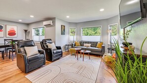 A modern living room with leather chairs, a sofa, a coffee table, and a large mirror. - Seatac Getaway! Fully Fenced w/ Workspace (SeaTac)