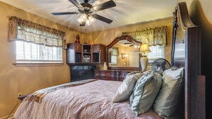 A bedroom with a bed, a ceiling fan, a dresser, a mirror, and a window with curtains. - Explore Baton Rouge! Cozy Retreat w/ Private Yard (Baton Rouge)