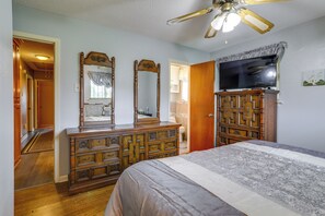 A bedroom with a bed, dresser, TV, and ceiling fan. - Explore Baton Rouge! Cozy Retreat w/ Private Yard (Baton Rouge)