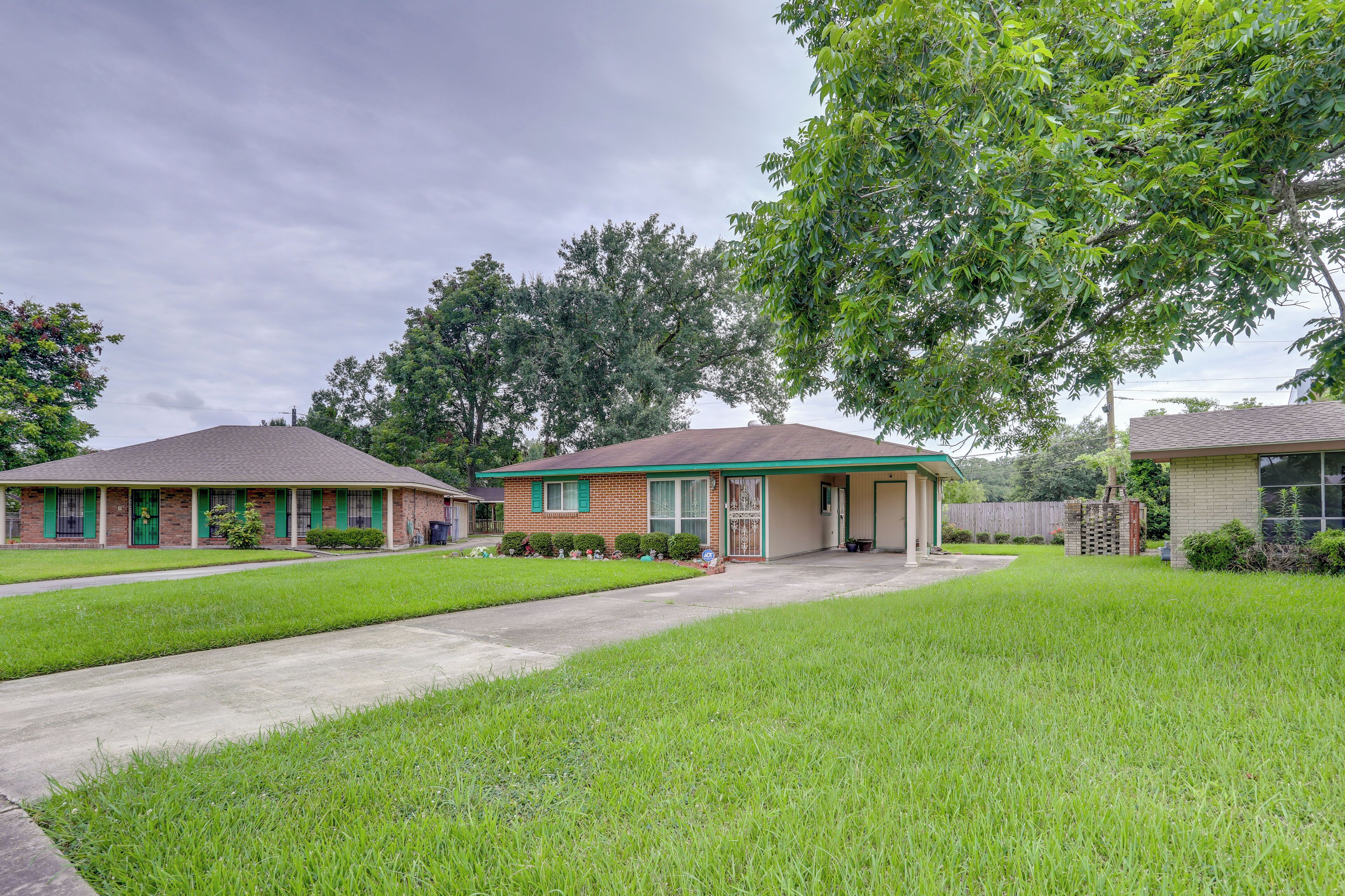 A suburban house with a front yard, a driveway, and a tree.