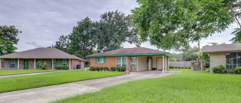 A suburban house with a front yard, a driveway, and a tree.