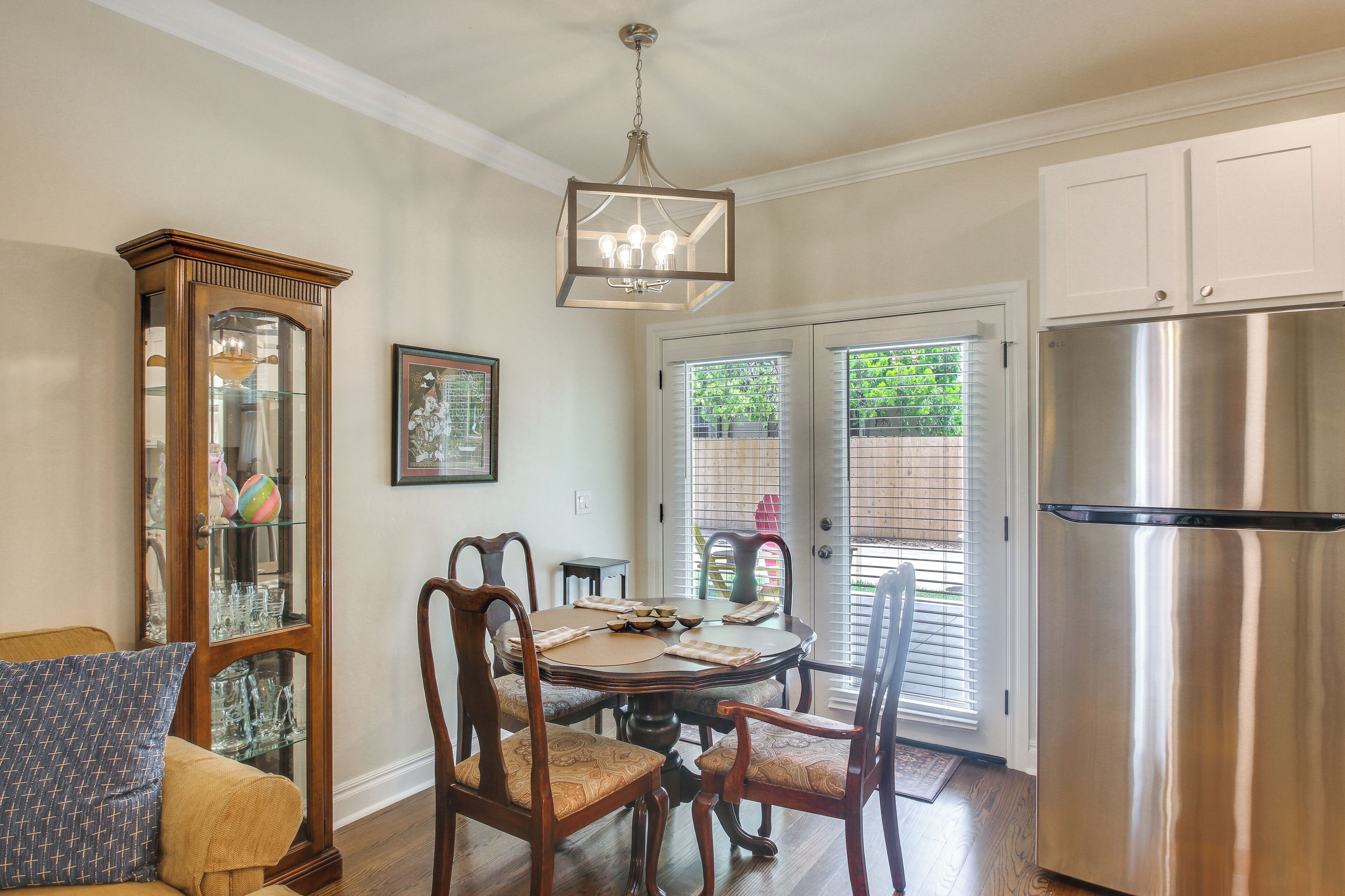 A dining area with a wooden table, chairs, and a chandelier.