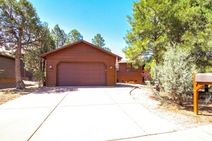 A single-story wooden building with a garage, surrounded by trees. - Outdoor Oasis w/ Fire Pit & Grill! Torreon Escape (Show Low)