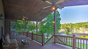 A covered deck with wicker furniture, a glass table, and a ceiling fan. - Dock, Games, Family Fun! Sunrise Beach Getaway (Sunrise Beach)
