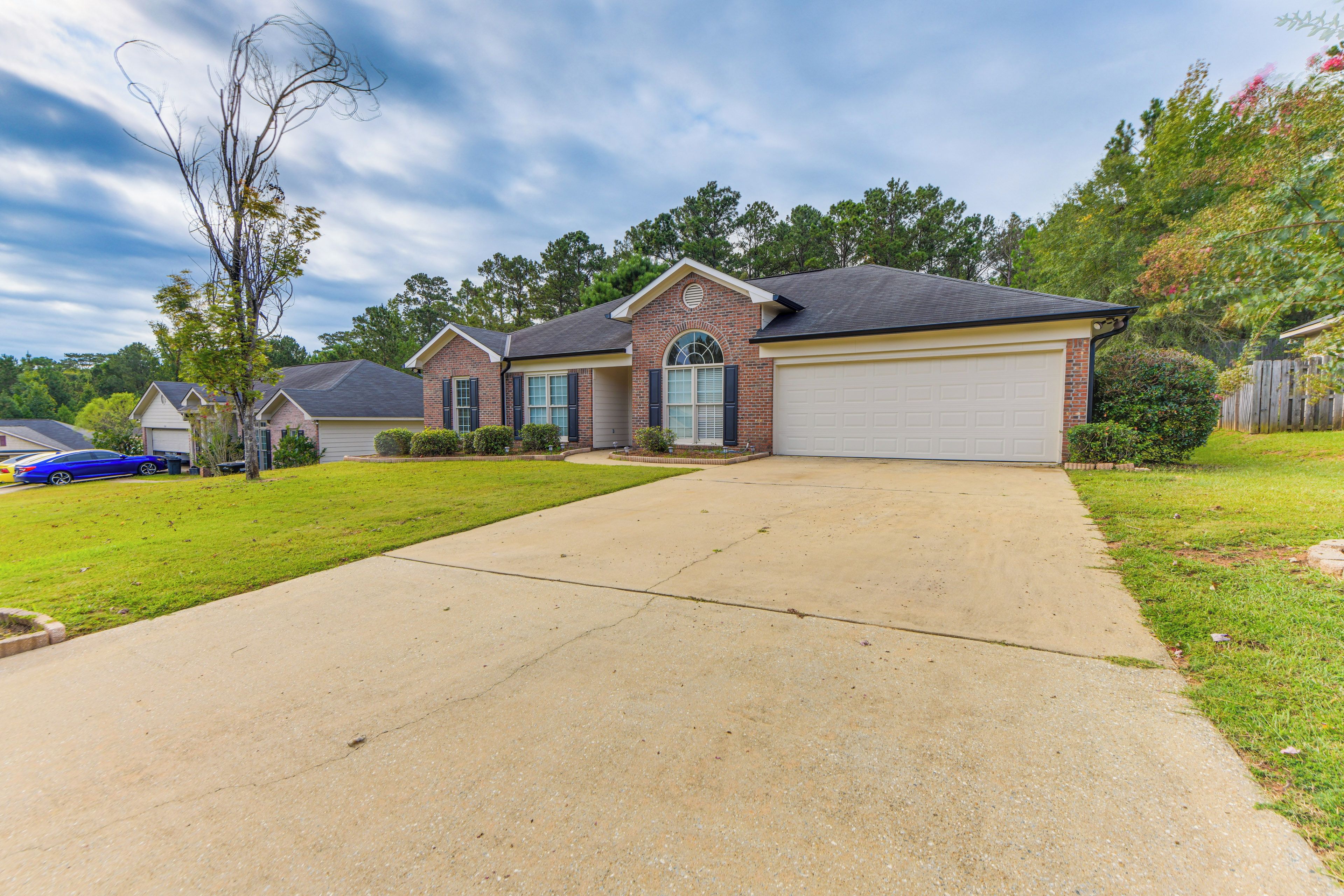 A residential house with a garage, a driveway, and a lawn.