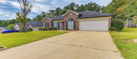 A residential house with a garage, a driveway, and a lawn.