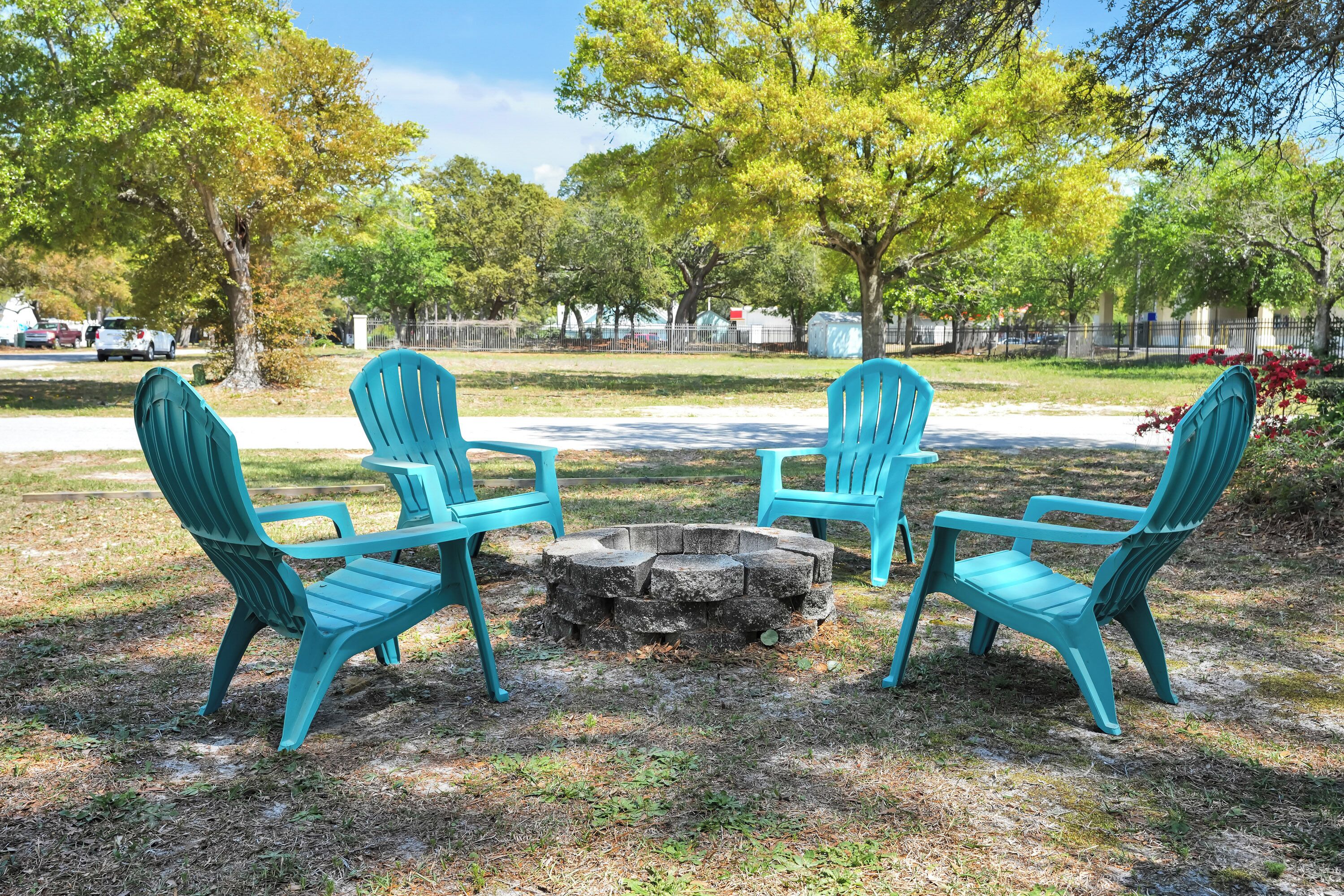 A circular seating arrangement with four chairs around a central fire pit in an outdoor setting.