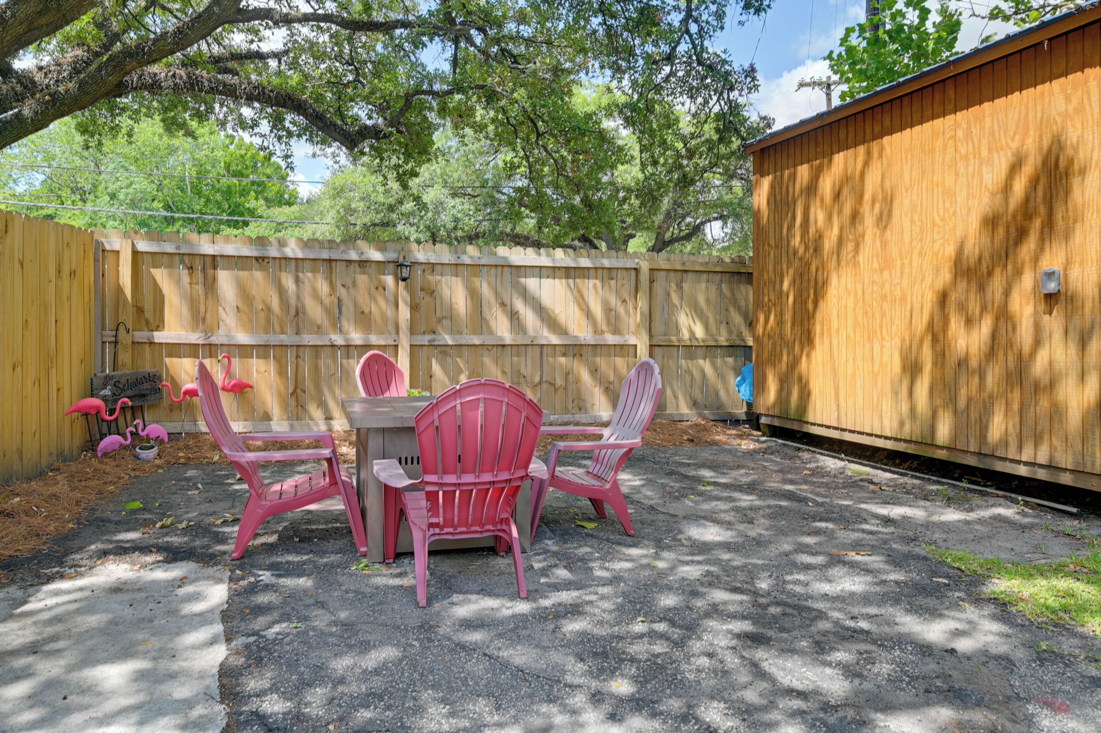 A patio with a table and chairs, a wooden fence, and a shed.
