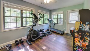 A home gym with exercise equipment, large windows, and a ceiling fan. - Day Trips to Gsmnp! Golfers Oasis in Franklin (Franklin)
