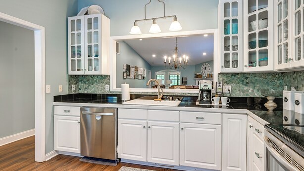 A kitchen with white cabinets, a stainless dishwasher, a chandelier, and a tiled backsplash. - Day Trips to Gsmnp! Golfers Oasis in Franklin (Franklin)