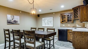 A dining area with a wooden table and chairs, a kitchen with wooden cabinets, a refrigerator, and a hanging world map. - Family Home w/ Patio, 9 Mi to Downtown Appleton (Greenville)