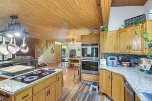 A kitchen with wooden cabinets, stainless steel appliances, and a granite countertop. - Peaceful Cabin Between Nashville & Bowling Green! (Portland)