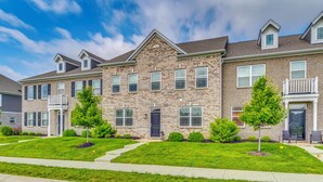 A row of townhouses with brick exteriors, front porches, and small front yards with trees. - Relax Poolside! Retreat 11 Mi to Eagle Creek Park (Whitestown)