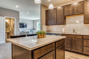 Una cocina moderna con armarios de madera, una isla central e iluminación colgante.