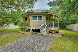 Uma casa pequena, térrea, com varanda e escada que dá para um deck.