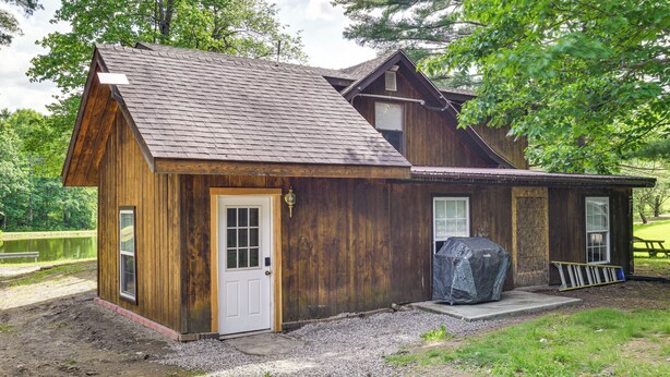 A wooden cabin with a sloped roof, a front door, and a covered porch area.