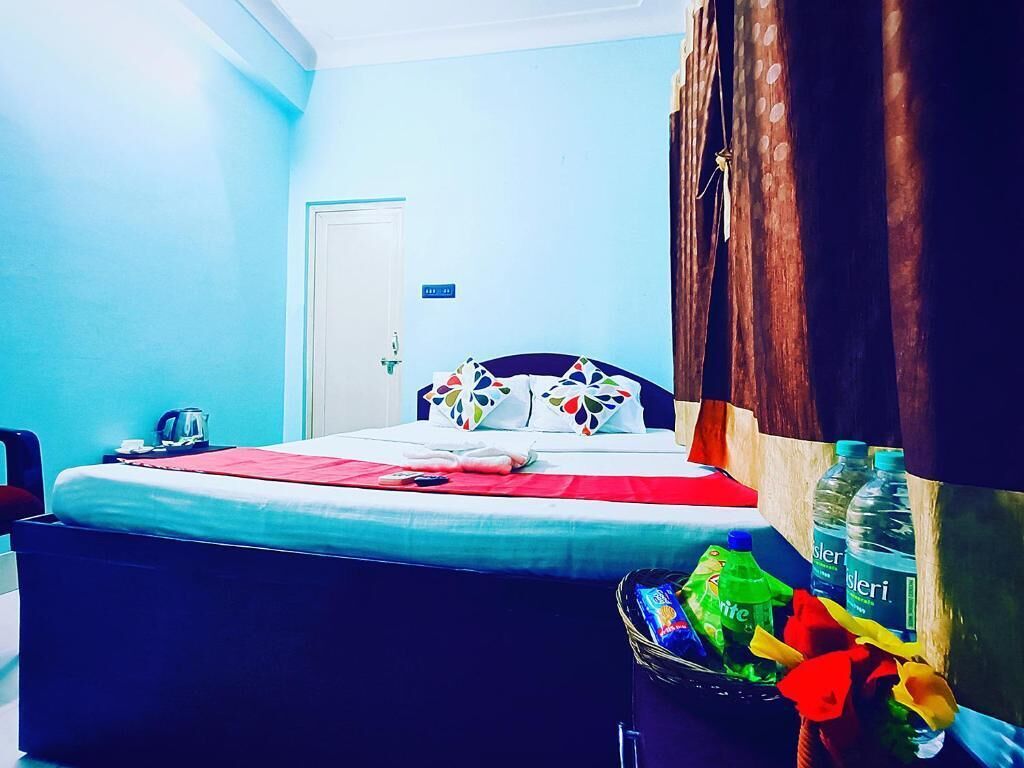 A bedroom with a bed, a trash bin, and a water bottle.